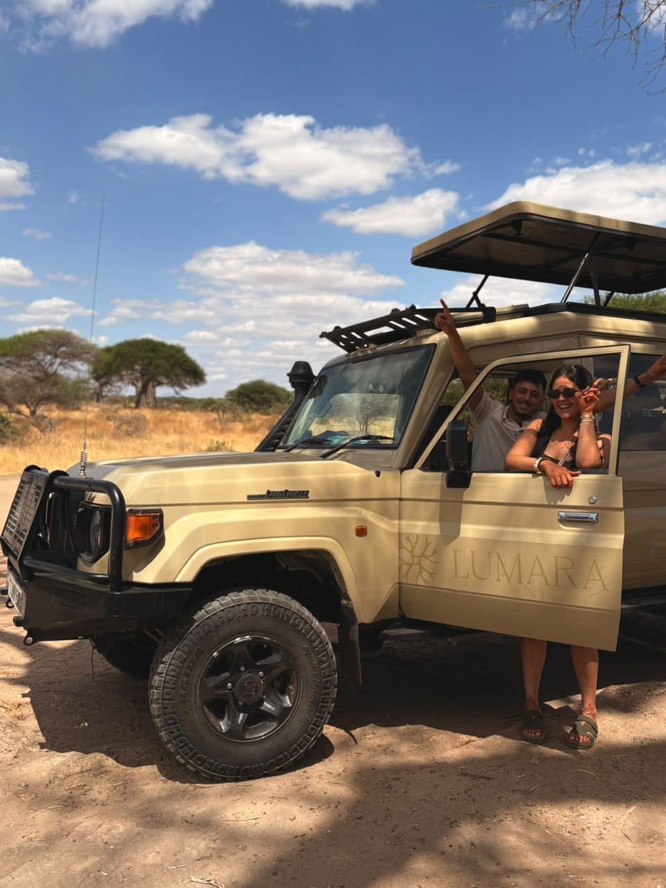 Ospiti accanto a un Land Cruiser Lumara durante il safari